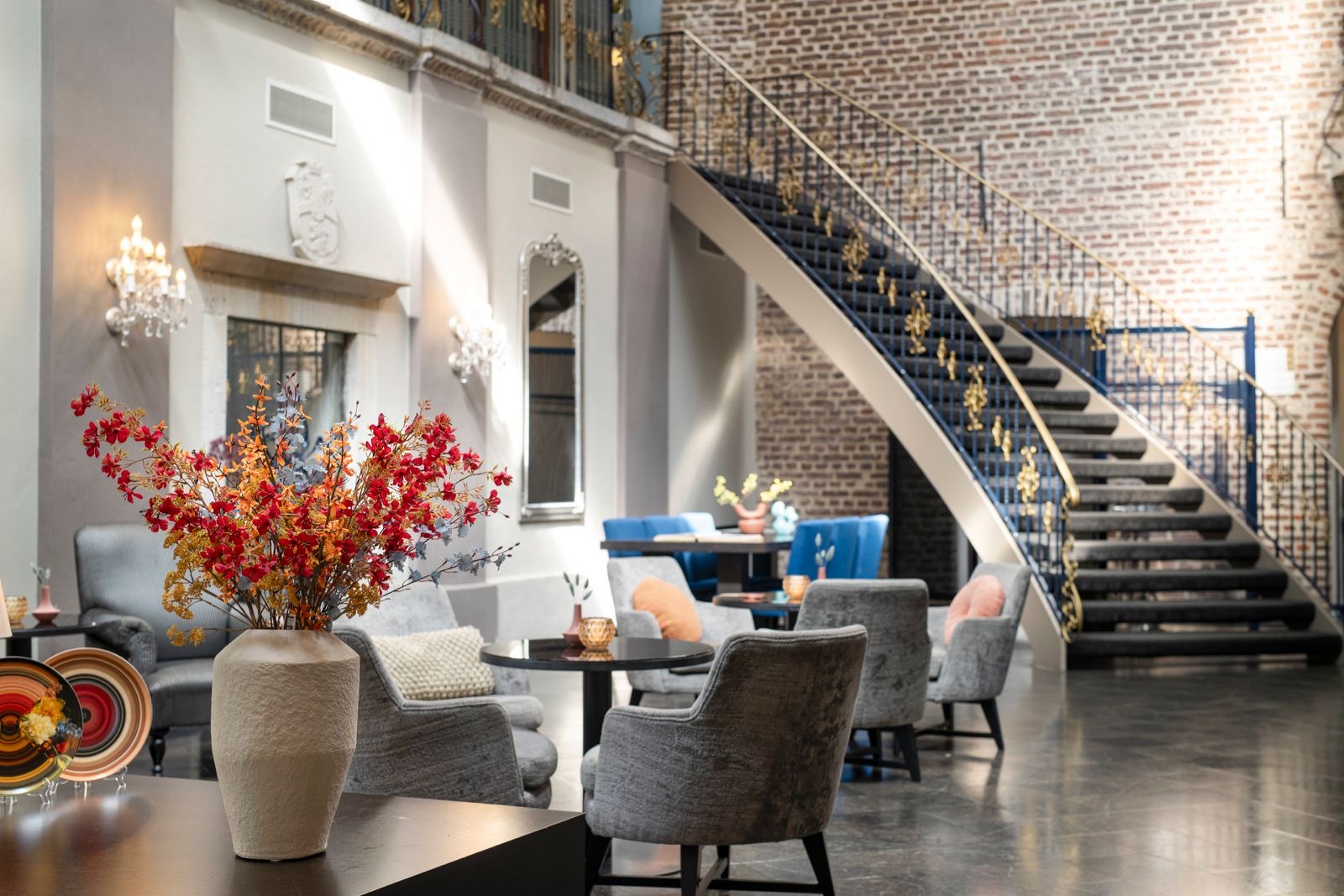 Elegante lounge met monumentale trap en bloemen